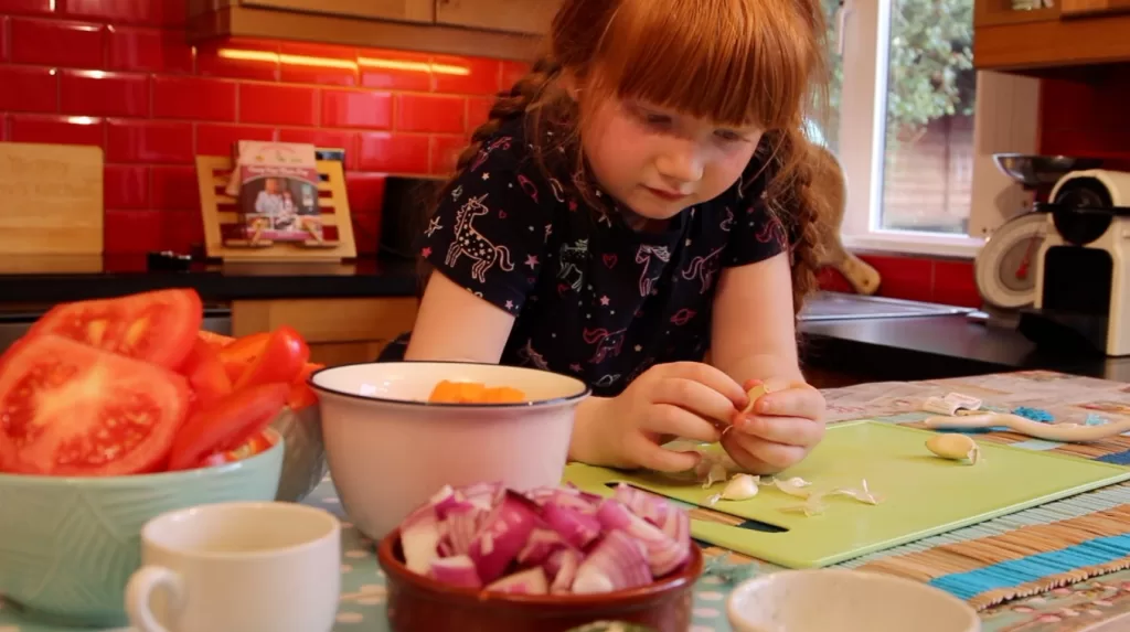 Lil's preparing garlic - Family Cooking Club